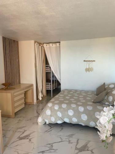 une chambre avec un lit et un bureau dans l'établissement Appartement en front de mer, à Sète