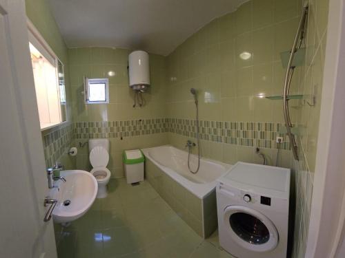 een badkamer met een wastafel, een bad en een toilet bij Apartments with a parking space Podstrana, Split - 22374 in Podstrana