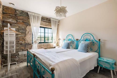 una camera con un letto blu e bianco e una finestra di 3 bedrooms chalet with private pool terrace and wifi at Corte a Castelo