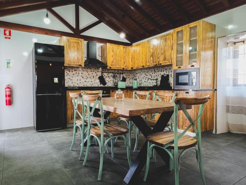 uma cozinha com uma mesa de madeira e cadeiras em Laura's Cottage AL em Velas