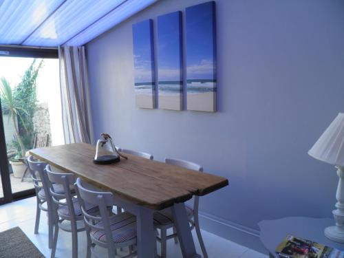 a dining room with a wooden table and chairs at Holiday House Pembroke Dock in Pembroke Dock