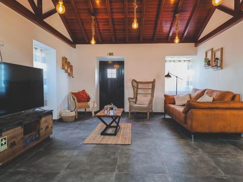 a living room with couches and a flat screen tv at Laura's Cottage AL in Velas