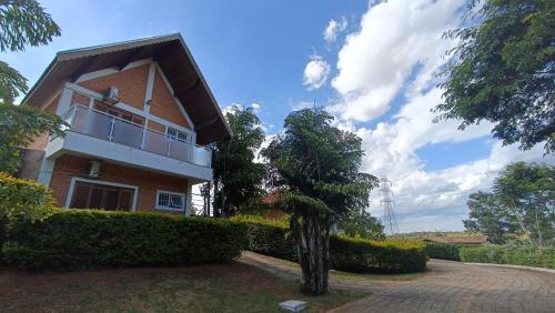 a house with a tree in front of it at Pousada Mandala Botucatu in Botucatu