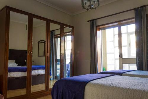 a bedroom with two beds and a mirror at One bedroom appartement at Vila Nova de Gaia 100 m away from the beach with wifi in Vila Nova de Gaia
