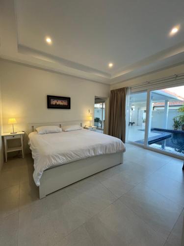 a bedroom with a large white bed and a balcony at VIEW TALAY VILLA POOL HOUSE 285 in Jomtien Beach