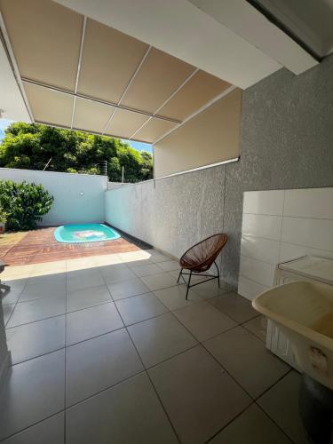 a room with a chair and a swimming pool at Casa com Piscina em Maringá in Maringá