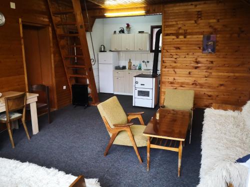 ein Wohnzimmer mit einem Tisch und Stühlen sowie eine Küche in der Unterkunft Mountain Lodge - Mavrovo in Mavrovo-Nationalpark