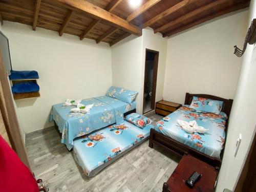 two twin beds in a room with wooden ceilings at Hotel La Sultana in Jardin
