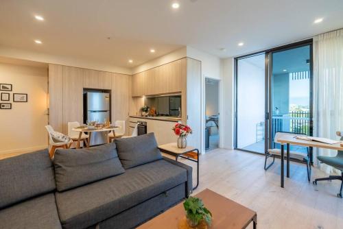 - un salon avec un canapé et une salle à manger dans l'établissement Chic Brand-New Apartment near South Brisbane & CBD with Pool + more, à Brisbane