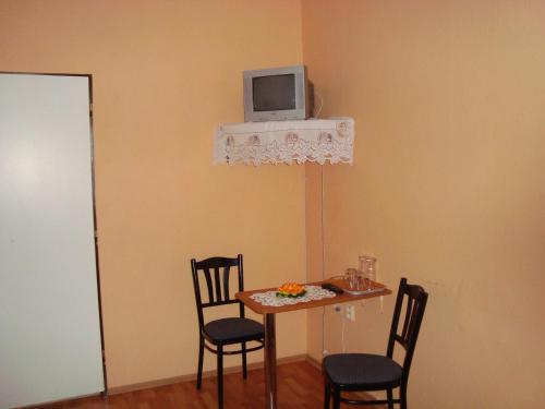 a dining room table with chairs and a tv on the wall at Penzion Adria in Turčianske Teplice