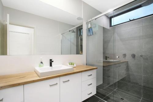un baño con lavabo y ducha en Delany by the Park - House, en Bright