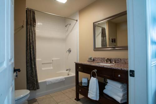 a bathroom with a sink and a tub and a toilet at Swift River Suites in Rumford