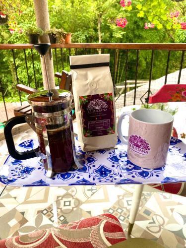 a table with a cup and a bag of coffee at Hotel La Sultana in Jardin