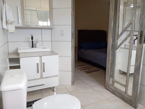 ein Bad mit einem WC, einem Waschbecken und einem Bett in der Unterkunft Férias!! Inspire-se e Renove! 7km centroMar Torres RS in Torres