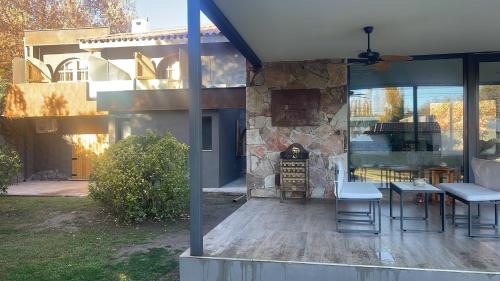 a patio with a stone fireplace next to a house at Terra Campo Posada in Chacras de Coria