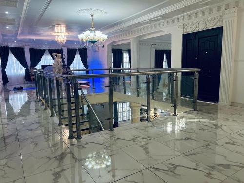 a lobby with a staircase and a chandelier at The Peacock Mansion in Kumasi