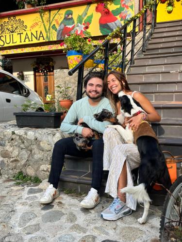 a man and woman sitting on steps with their dogs at Hotel La Sultana in Jardin