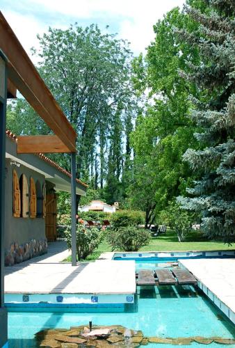 a swimming pool next to a house with trees at Terra Campo Posada in Chacras de Coria