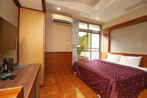 a hotel room with a bed and a window at Yosemite Hot Spring Resort in Baihe