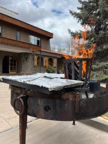 a large grill with a fire in front of a building at Terra Campo Posada in Chacras de Coria