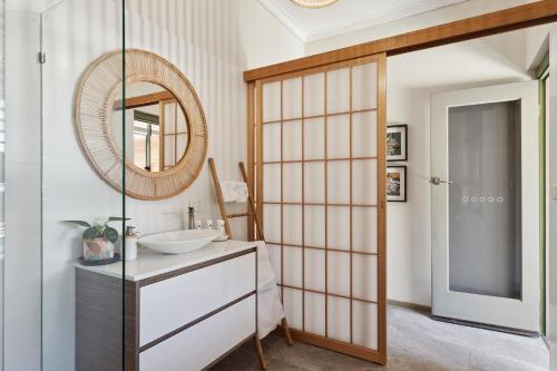 a bathroom with a sink and a mirror at Haven Studio Hideaway near Airport in Perth