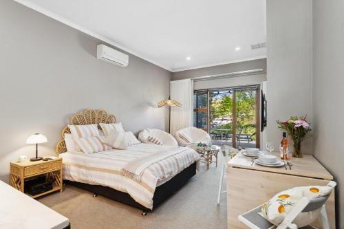 1 dormitorio con cama extragrande y mesa en Haven Studio Hideaway near Airport en Perth