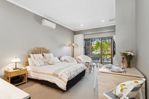 a bedroom with a king sized bed and a table at Haven Studio Hideaway near Airport in Perth