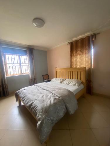 a bedroom with a bed and a window at Pal central nest in Kampala