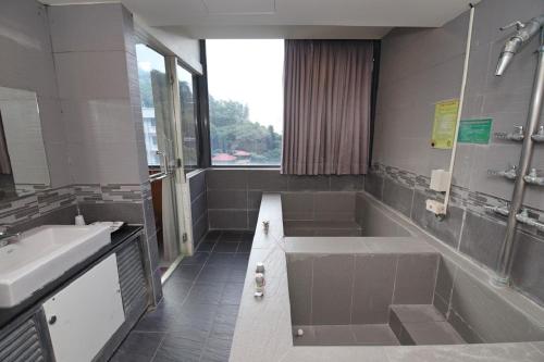uma grande casa de banho com banheira e lavatório em Yosemite Hot Spring Resort em Baihe