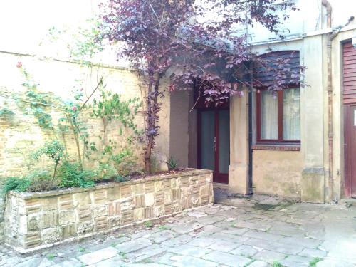 a house with a stone wall and a tree at Dieppe Coeur de Ville in Dieppe