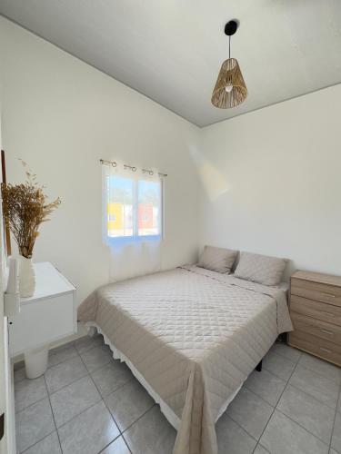 a white bedroom with a bed and a window at Alojamiento entero en San Miguel in San Miguel