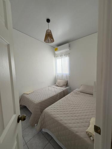 twee bedden in een kamer met witte muren bij Alojamiento entero en San Miguel in San Miguel