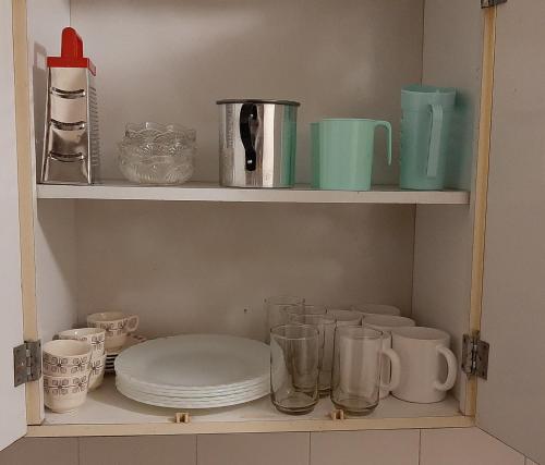 a shelf with plates and cups and other items on it at Apart Decorama in Dolores