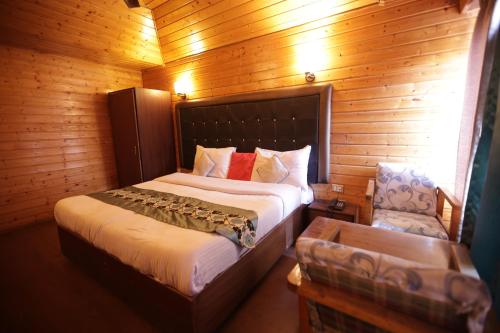 a bedroom with a large bed and a chair at Lake Resort The Island Hotel in Srinagar