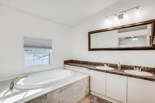 Baño blanco con 2 lavabos y espejo grande en Waterfront Trinity Vacation Rental with Hot Tub!, en Riverside