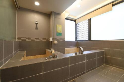 a bathroom with a large sink and a mirror at Yosemite Hot Spring Resort in Baihe