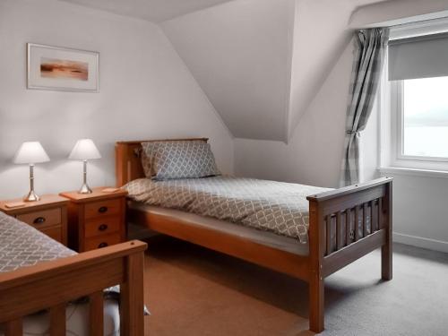sypialnia z łóżkiem i oknem w obiekcie Sunnybank Cottage w mieście Inveralligin