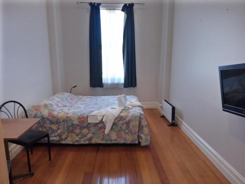a bedroom with a bed and a table and a television at Austral Inn in Quorn
