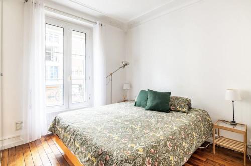 une chambre blanche avec un lit et une fenêtre dans l'établissement Spacious bright apartment in Montmartre Paris, à Paris
