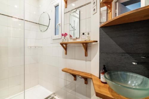 La salle de bains est pourvue d'un lavabo en verre et d'une douche. dans l'établissement Spacious bright apartment in Montmartre Paris, à Paris