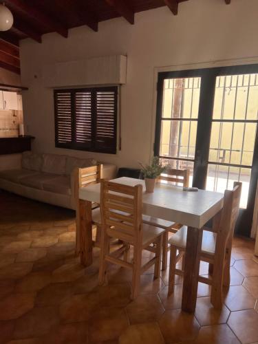 a dining room with a table and chairs and a couch at ALQUILER LAS FLORES in Las Flores