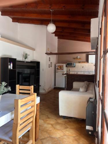 a bedroom with a bed and a table and a kitchen at ALQUILER LAS FLORES in Las Flores