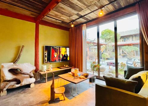 a living room with a couch and a table at Qushe Snowy Mountain View Art B&B in Lijiang