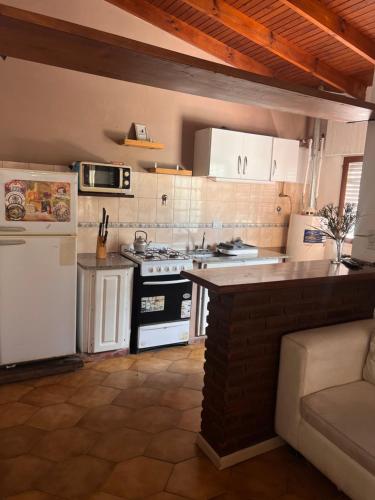 a kitchen with a stove and a white refrigerator at ALQUILER LAS FLORES in Las Flores