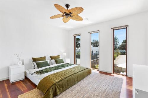 a bedroom with a bed and a ceiling fan at The Ultimate Getaway in Portsea