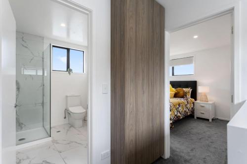 a bedroom with a bed and a shower and a toilet at Luxury Style Free Street Parking CBD Location in Christchurch