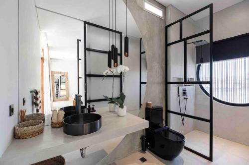 a bathroom with a sink and a mirror at Baliwood Villas - OCEAN VIEW 3BR in Canggu
