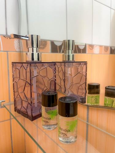 three bottles of essential oils sitting on a glass shelf at La Flamboyant Hotel in Roseau