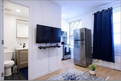 een keuken met een koelkast en een tv aan de muur bij 69-3D Prime Lower East East BRAND NEW 1br Apt in New York