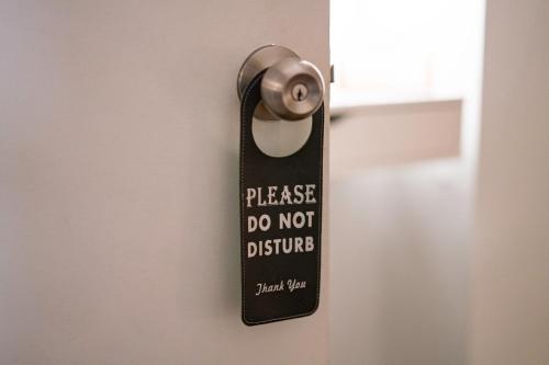 a door handle with a do not disturb sign on it at Private room with private bathroom and backyard in Brooklyn